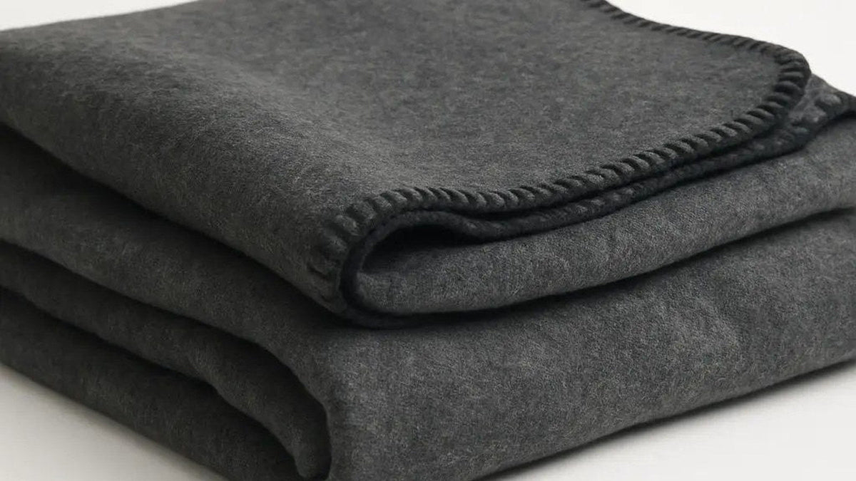 Folded charcoal gray wool blend blanket on a clean surface, ready for a government order by stock number