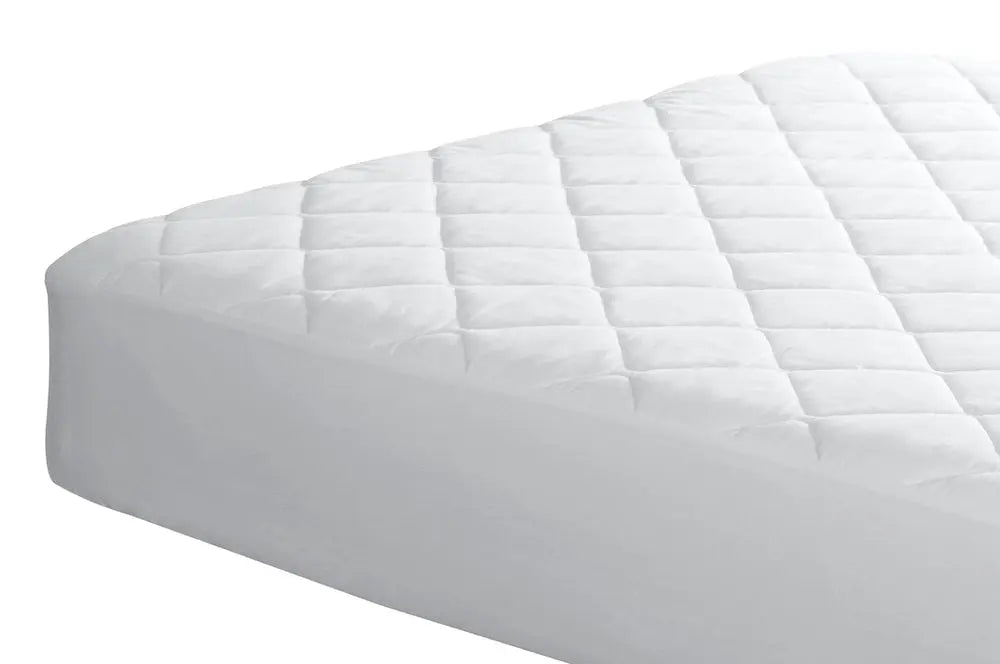 Quilted mattress pad on hotel bed