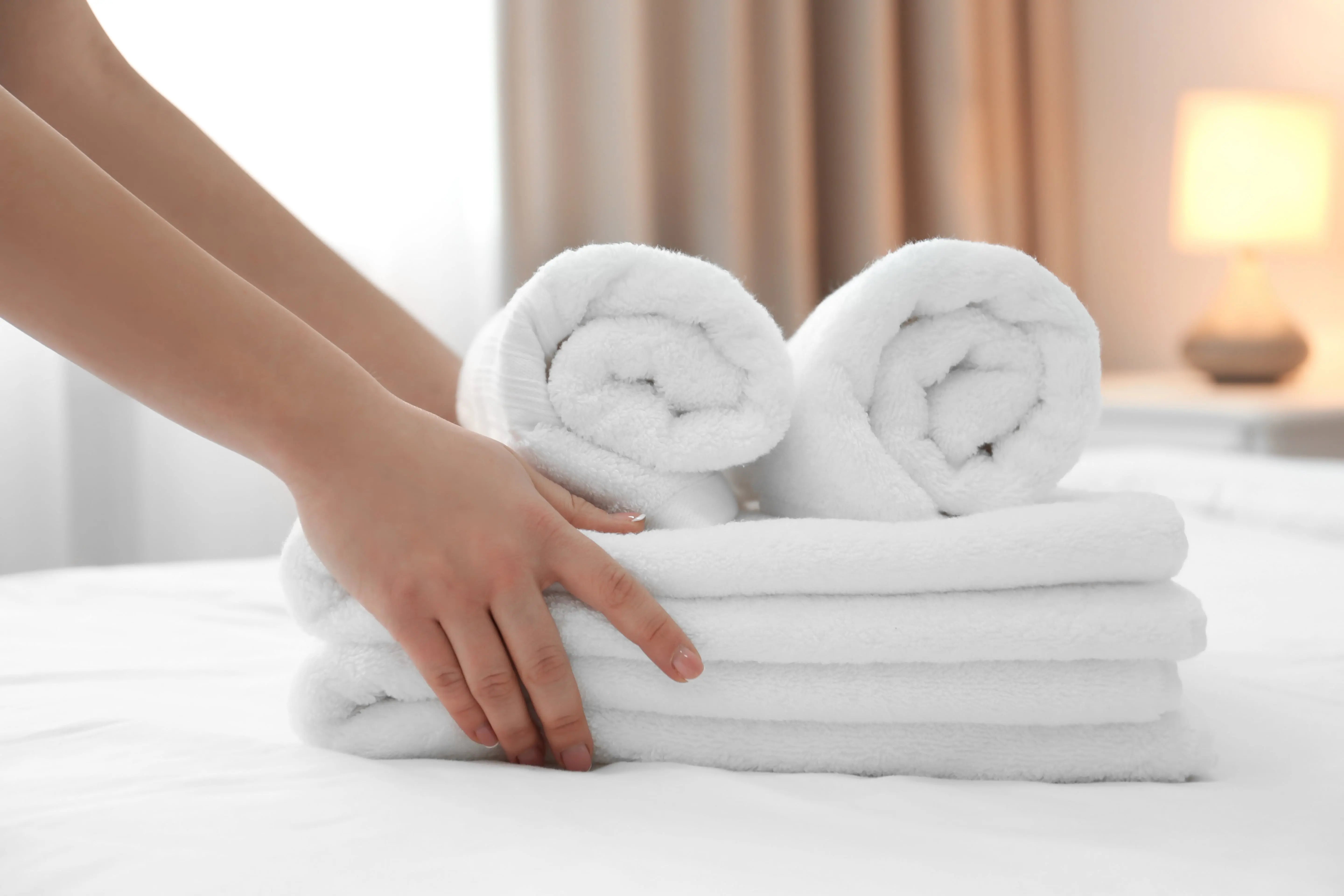 White hotel towels neatly folded on bed