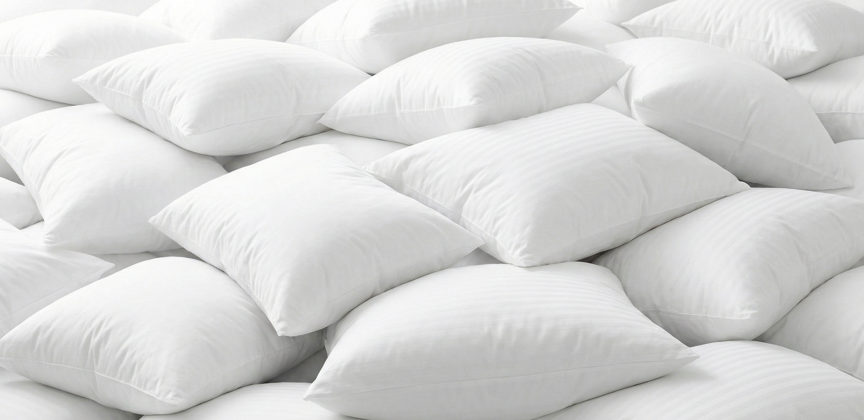 Large pile of plush white wholesale hotel pillows, highlighting bulk availability for hospitality procurement.
